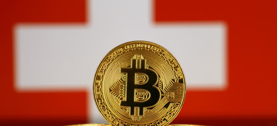 Version physique du bitcoin et drapeau suisse. 