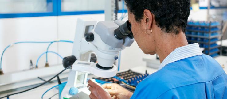 Frau untersucht Proben unter dem Mikroskop