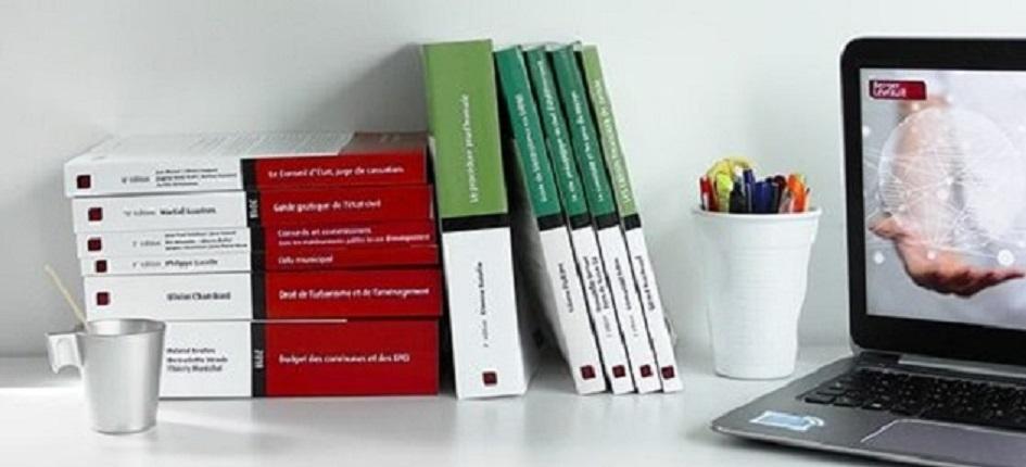 A computer and some Berger-Levrault manuals on a table.