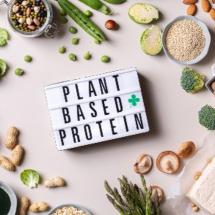 "plant based proteins" sign surounded by food