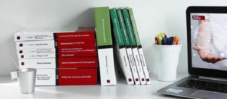 A computer and some Berger-Levrault manuals on a table.