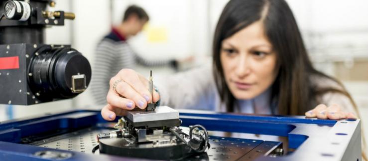 mujer preparando una máquina en un laboratorio