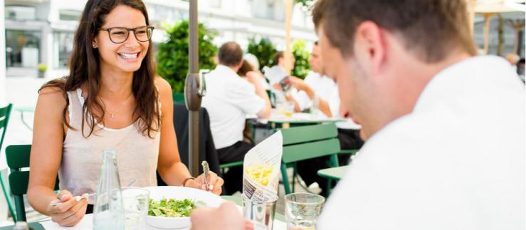 Dos jóvenes almuerzan afuera en un restaurante 