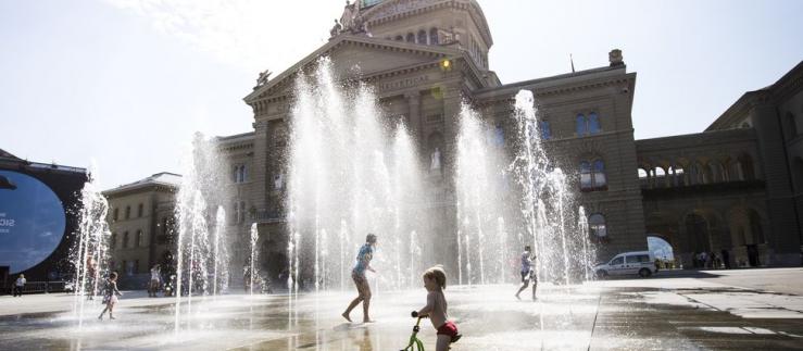 Дети играют перед зданием Федерального дворца в Берне