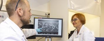 Jolanta Janczak-Rusch und Bastian Rheingans diskutieren die Mikroskopie-Aufnahme einer Fügezone, die mit einem Nanojoining-Verfahren hergestellt wurde.