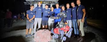 The Swiss team with one of their walking robots and astronaut Matthias Maurer (center) at the Space Resources Challenge. 