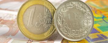 euro and swiss franc coin on banknotes 
