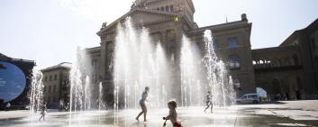 Crianças brincam na frente do Palácio Federal, em Berna 